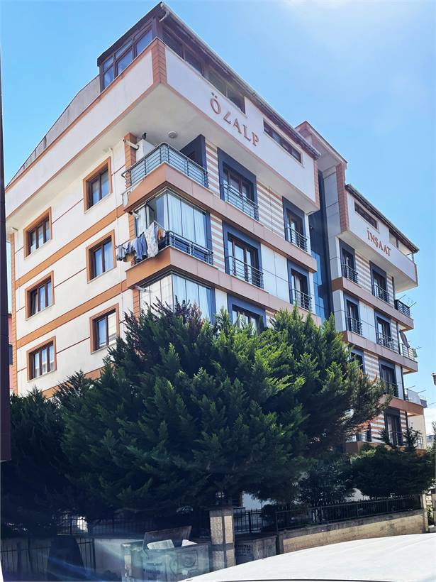 Ağaçlarla çevrili tamamlanmış Özalp İnşaat binası